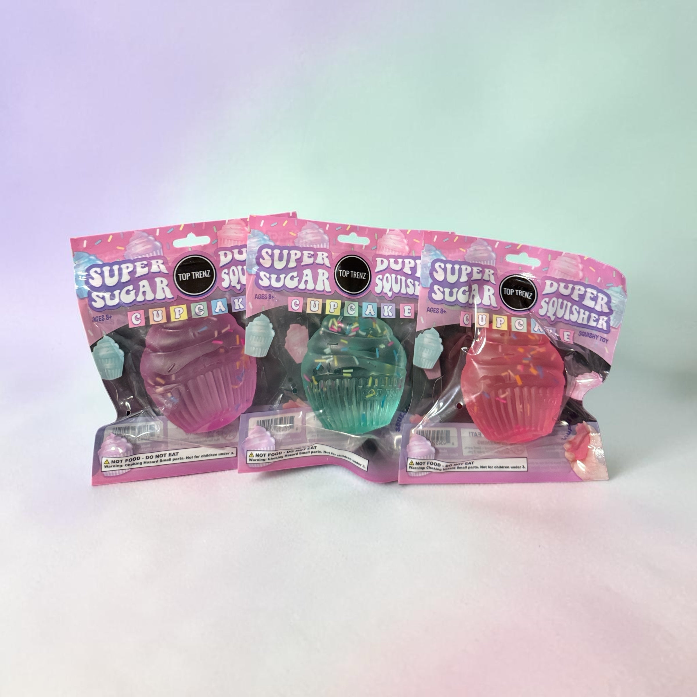 Trendzy Creations TOP TRENZ Super Sugar Duper Squisher cupcake toys in pink, teal, and red translucent jelly textures.