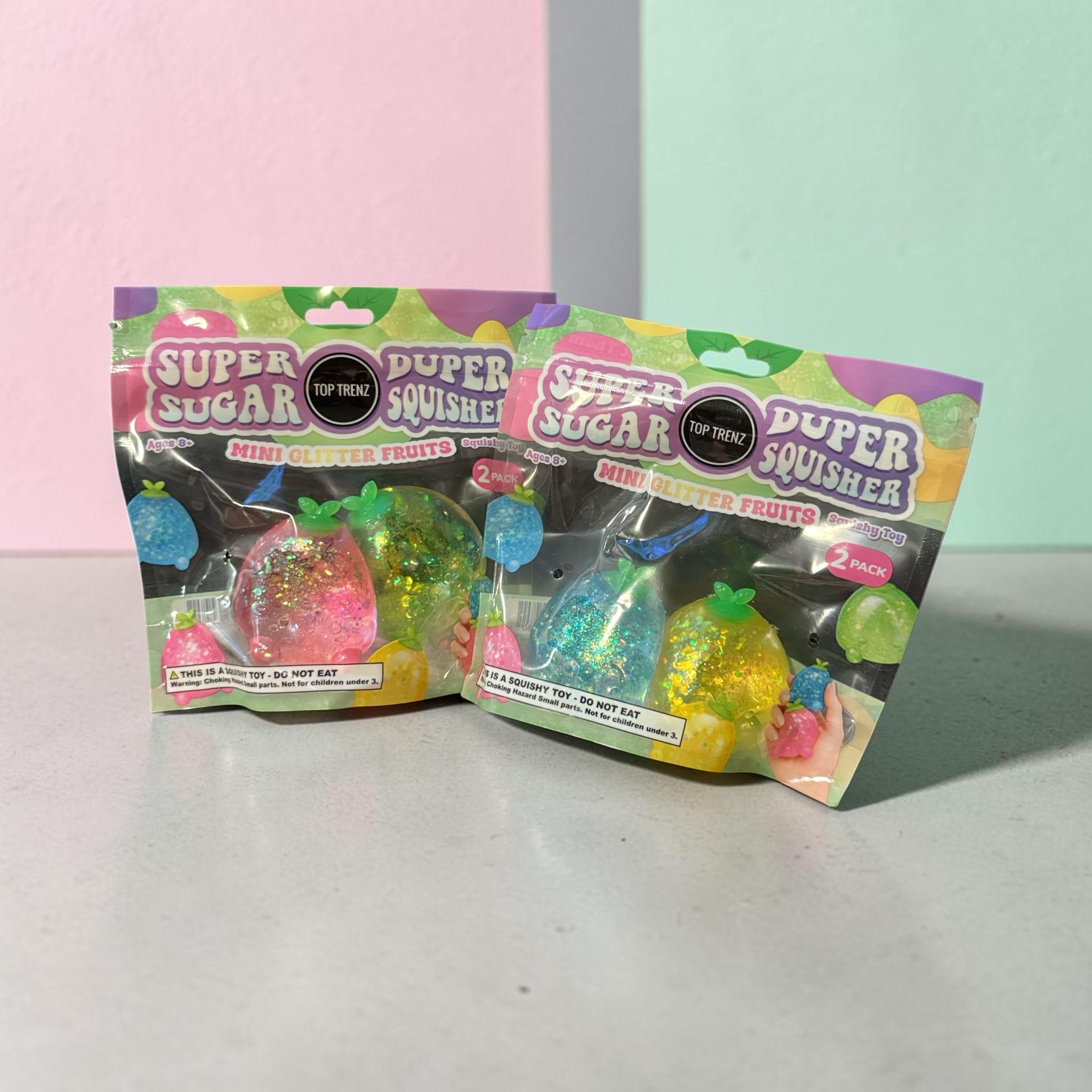 Trendzy Creations TOP TRENZ glittery fruit-shaped squishy toys in two-pack retail packaging for sensory play.